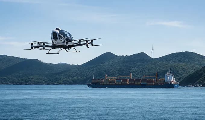 En EHang EH216-S flyger över vattnet framför ett lastfartyg